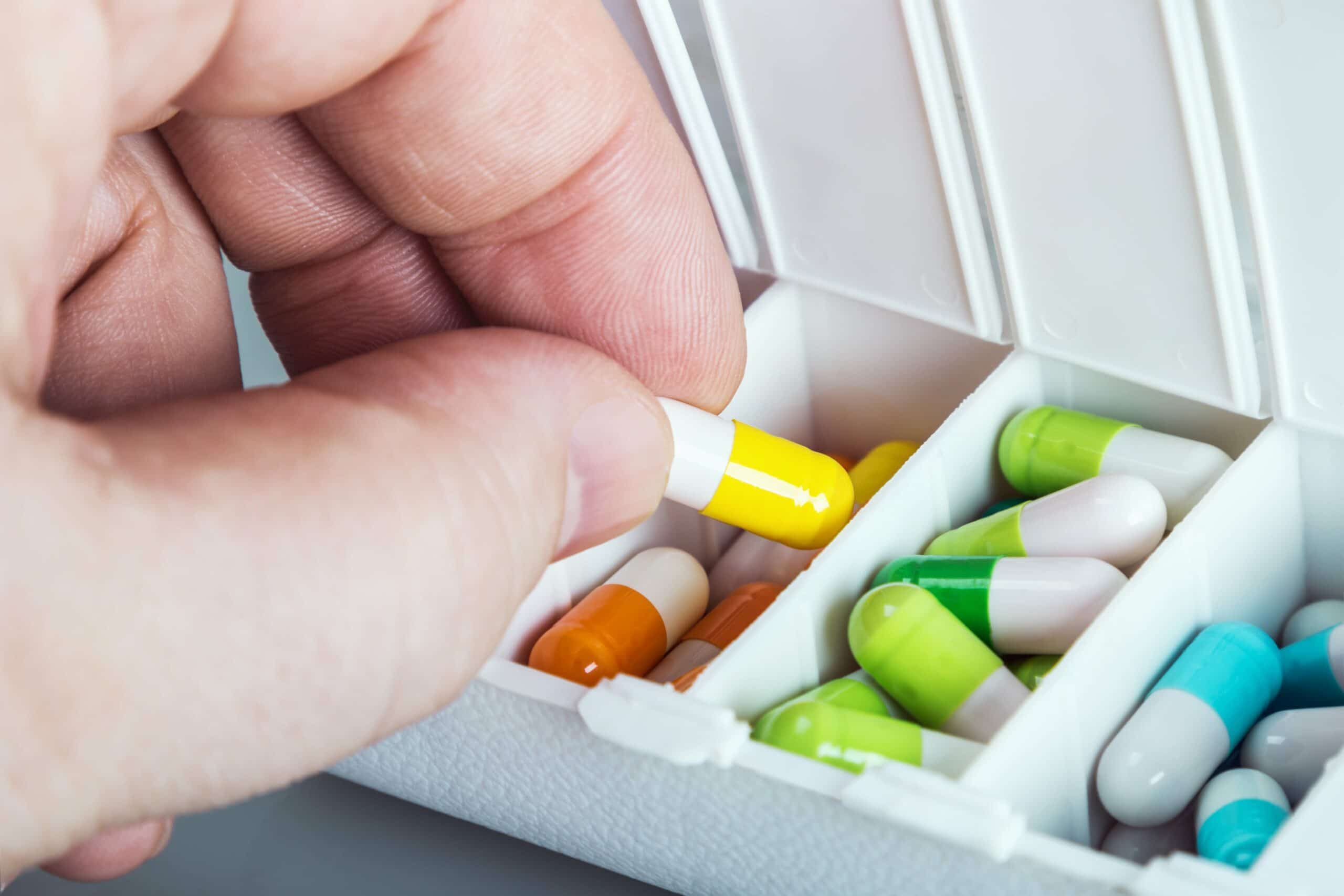 Person taking medication out of pill box