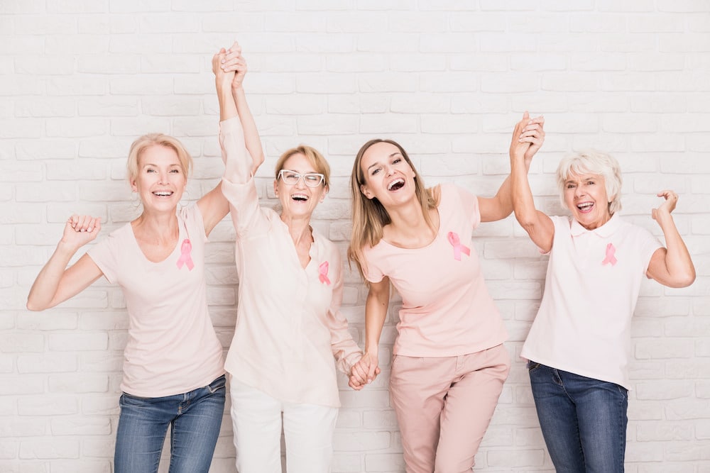 Smiling ladies wearing pink for Breast Cancer Awareness Month