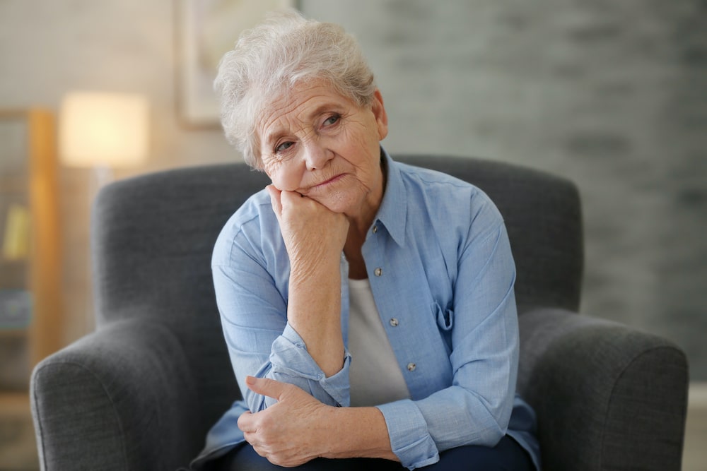 Tired elderly woman sitting in a chair