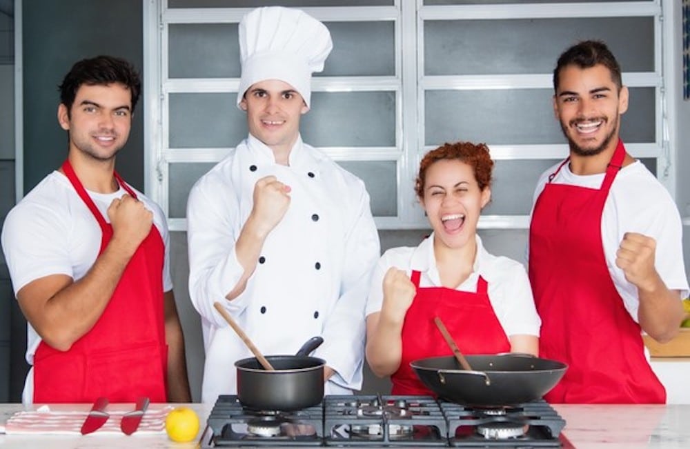 Cheering chef with team at kitchen People cooking in kitchen.